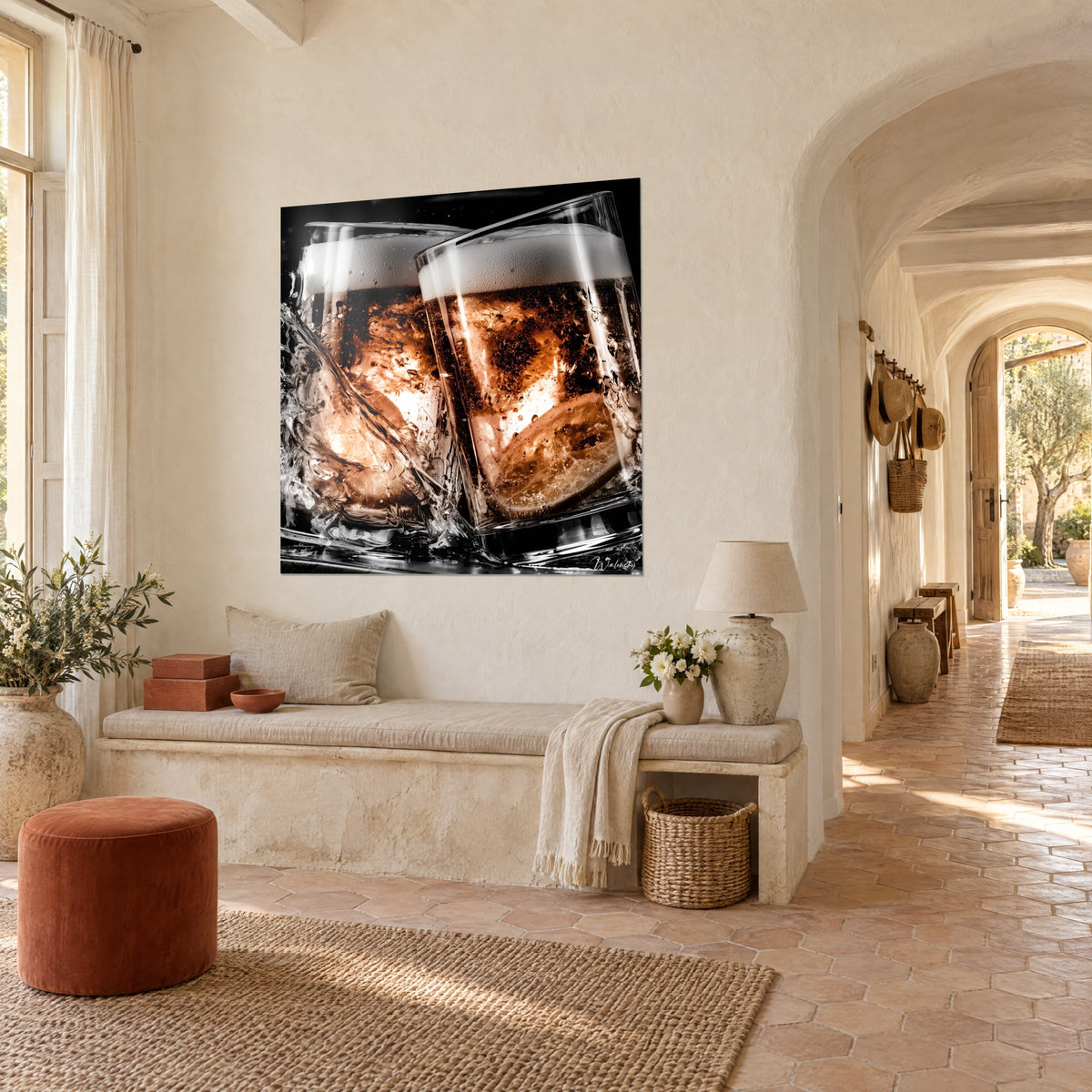 Quadro scenografico di due bicchieri spumeggianti su fondo nero, liquido bruno ramato, schizzi d'acqua, soggiorno di un mas provenzale