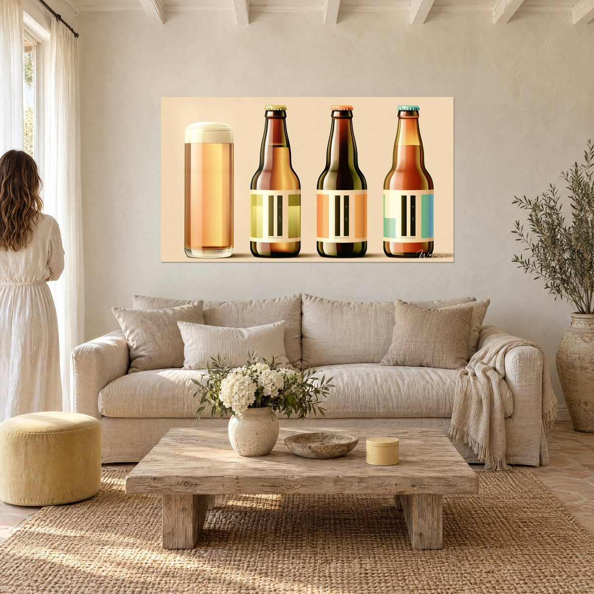 Wall art golden beer glass and three amber and olive green bottles, cream labels, above a sofa in a bright living room