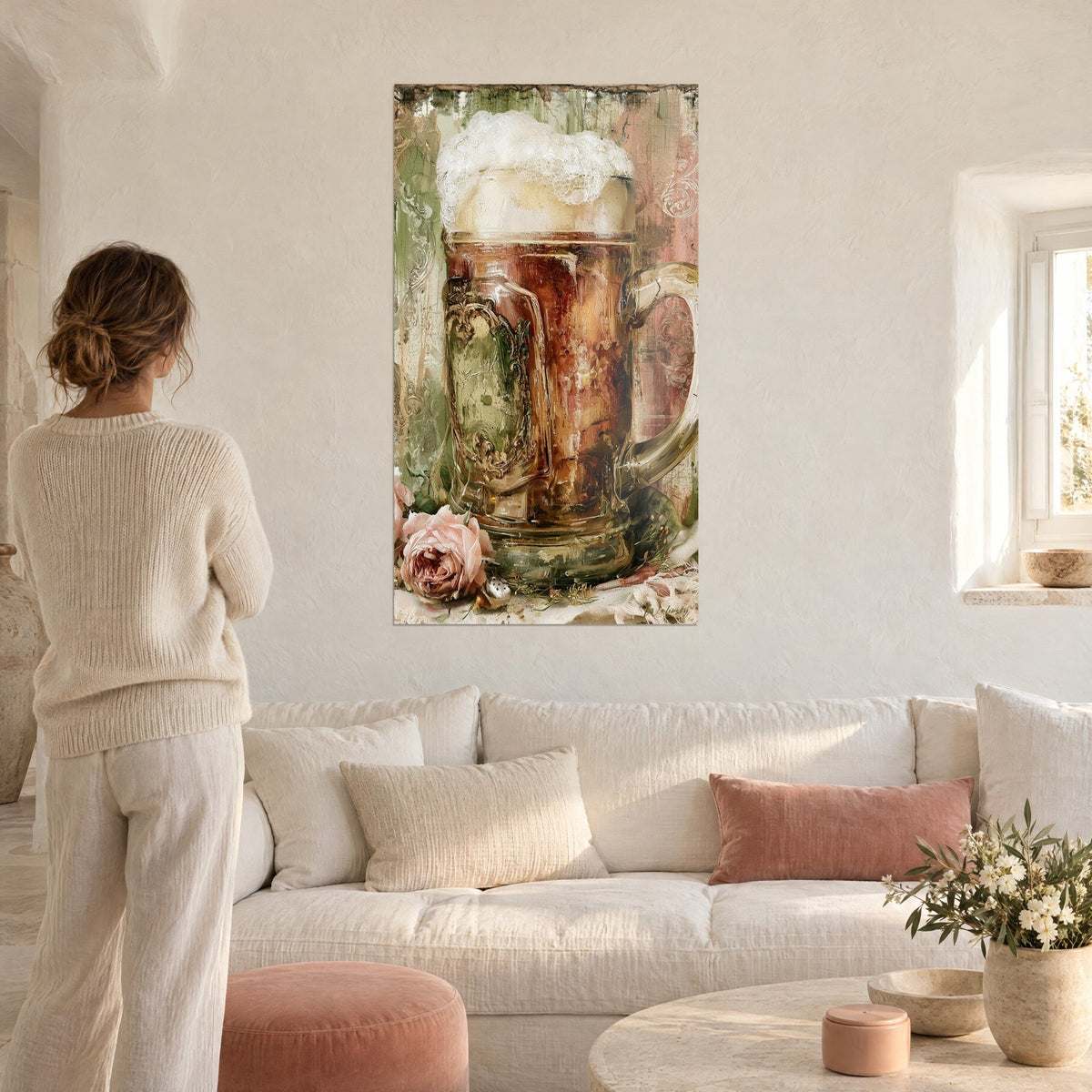 Tableau chope de bière ambrée sous une mousse crémeuse, roses poudrées et fond vert sauge, au-dessus d'un canapé dans un salon lumineux