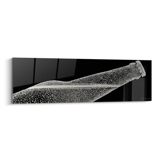 Bouteille de bière noire et blanche couverte de gouttelettes glacées, inclinée en diagonale