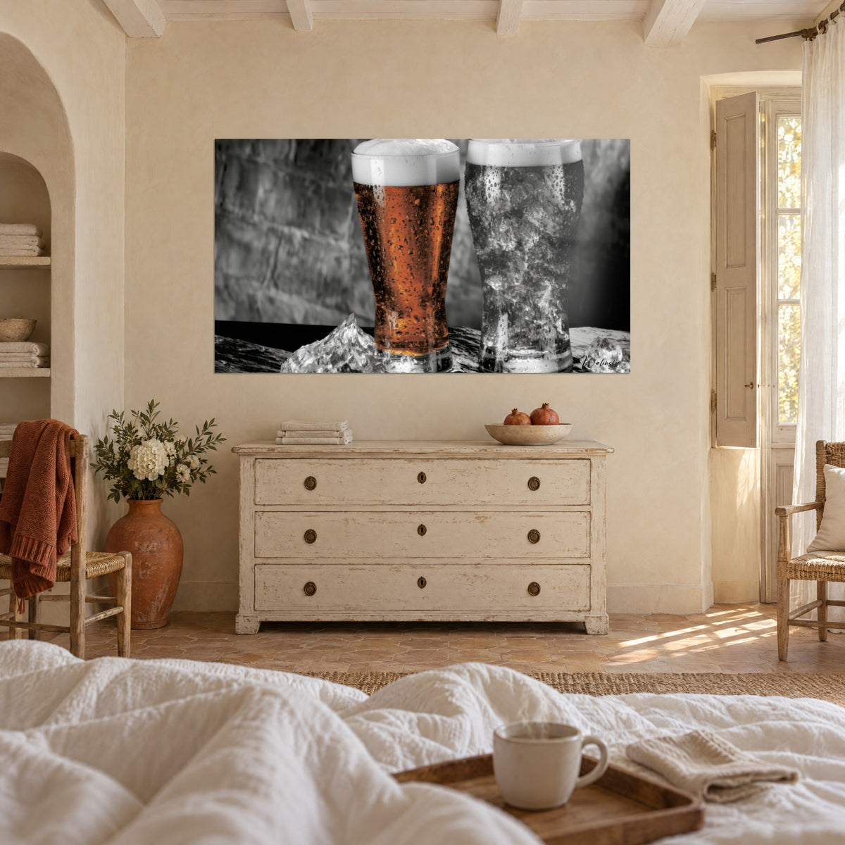 Tableau bière orangée surmontée de mousse crème et pinte de glace grise, au-dessus d'un lit dans une chambre claire