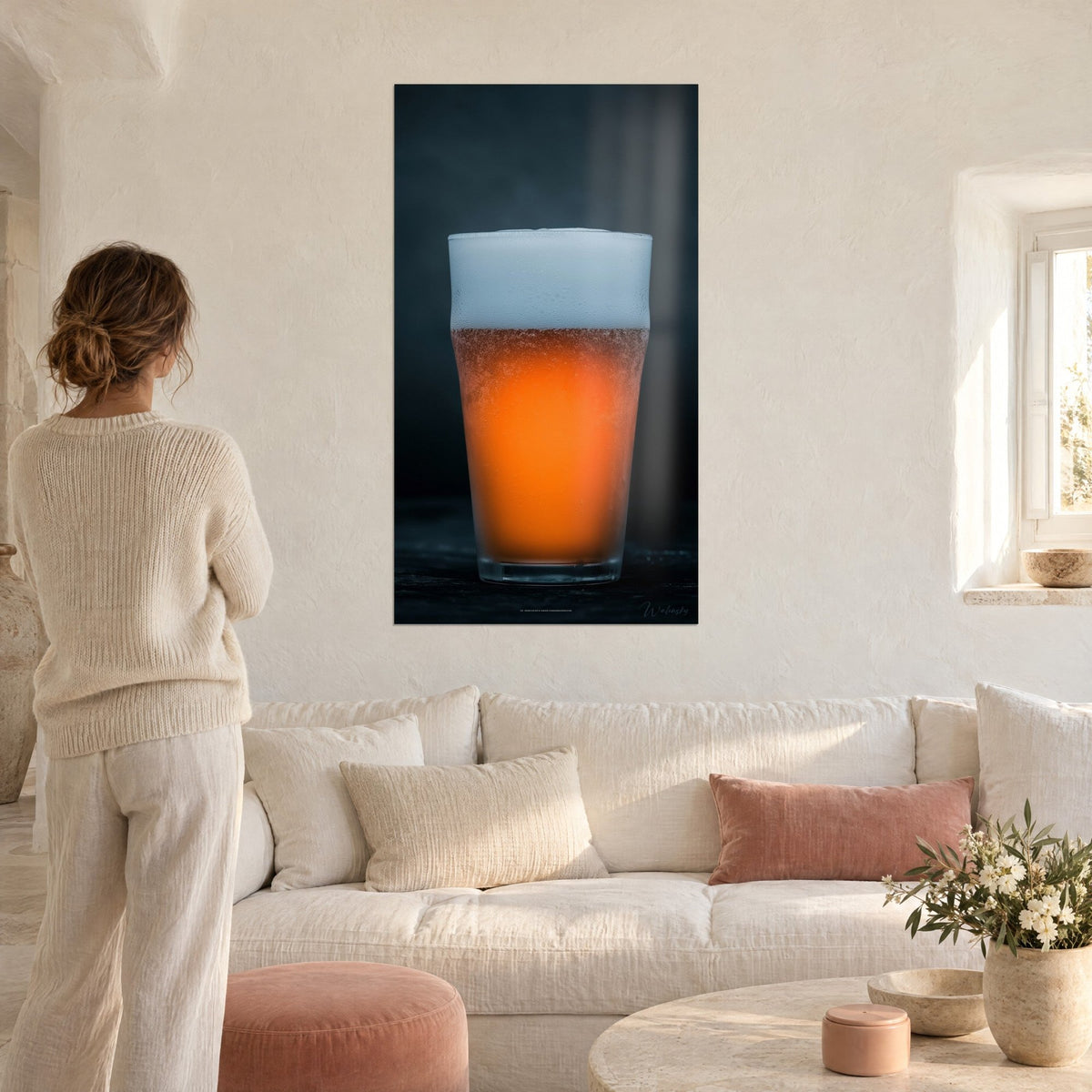 Tableau pinte de bière ambrée sous sa mousse blanche, orange vif sur fond anthracite, au-dessus d'un canapé dans un salon lumineux