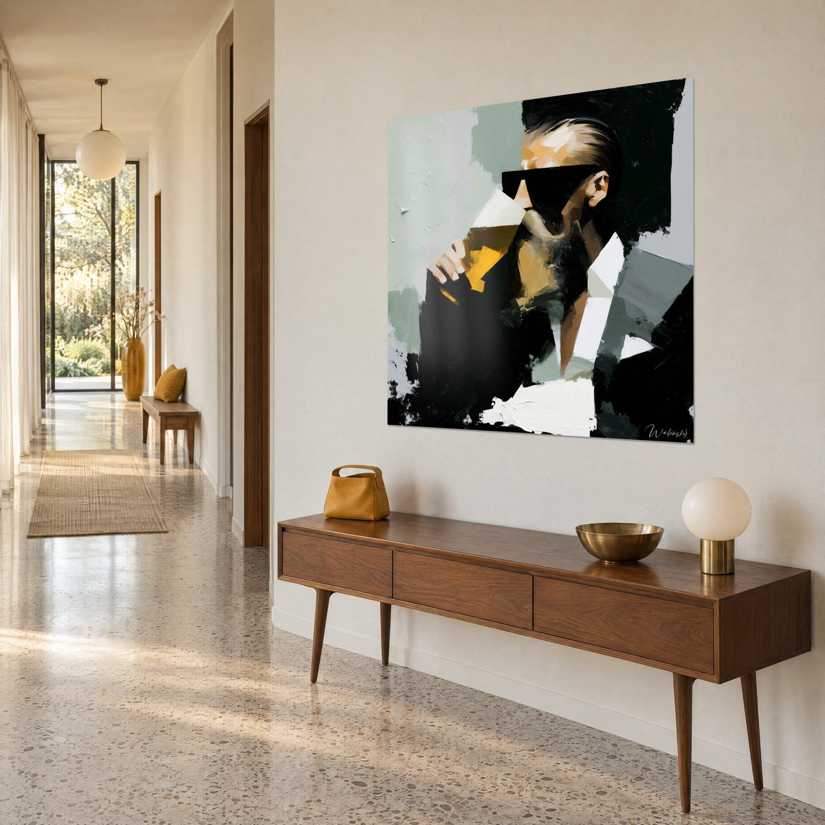 Schilderij mannelijke silhouet met een amberkleurig geel glas, saliegroene en diep zwarte penseelstreken, op een beige muur naast een houten console