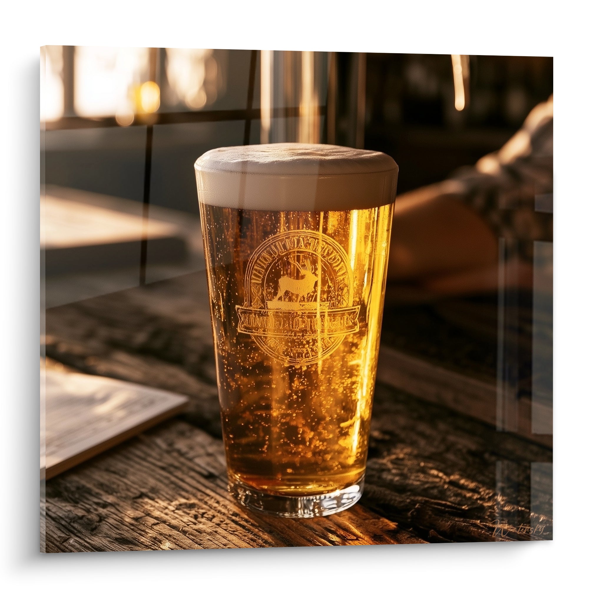 Verre de bière ambré et mousse blanche gravé d'un cerf, lumière dorée sur table en bois