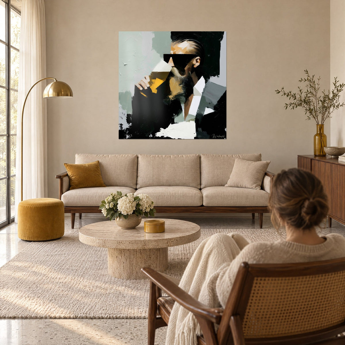Schilderij man met zwarte zonnebril die een gouden bier drinkt, antracietkleurige jas en witte kraag, boven een bank in een lichte woonkamer