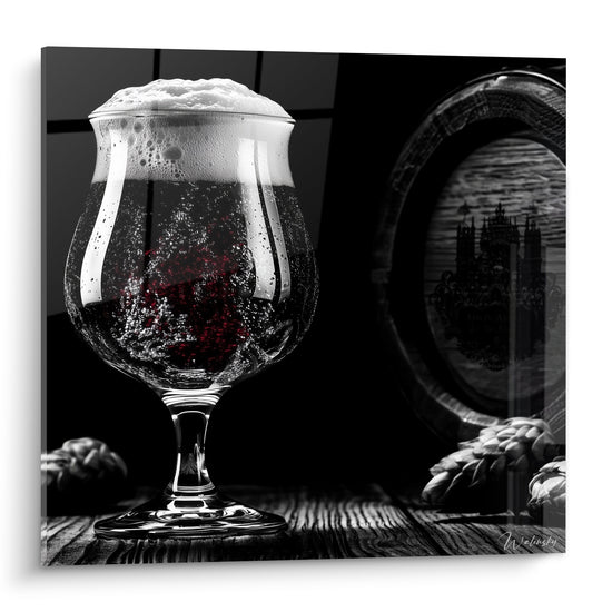 Verre de bière fauve à mousse blanche débordante devant un tonneau noir en arrière-plan