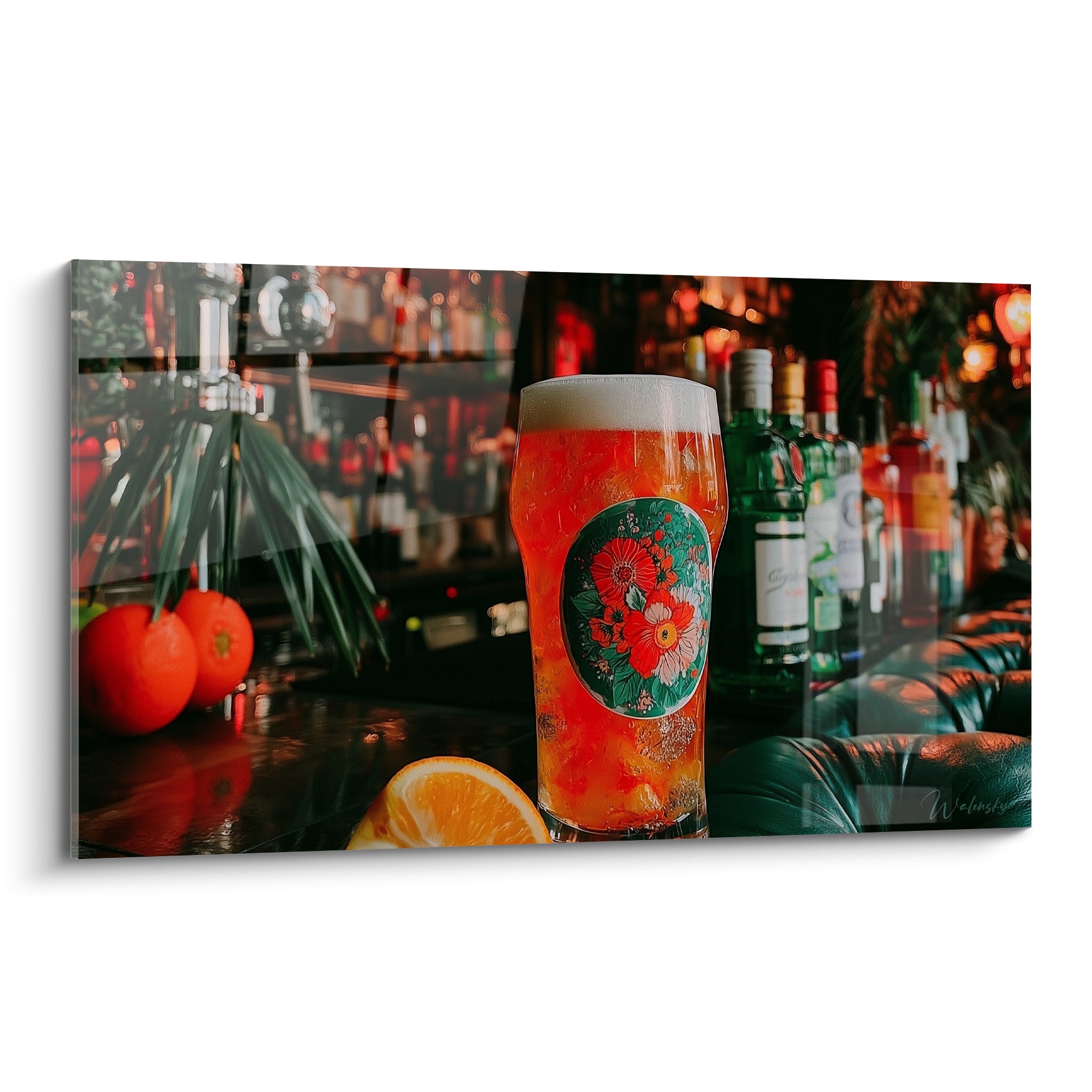 Verre bière orangé et mousse blanche, étiquette florale verte, comptoir de bar sombre