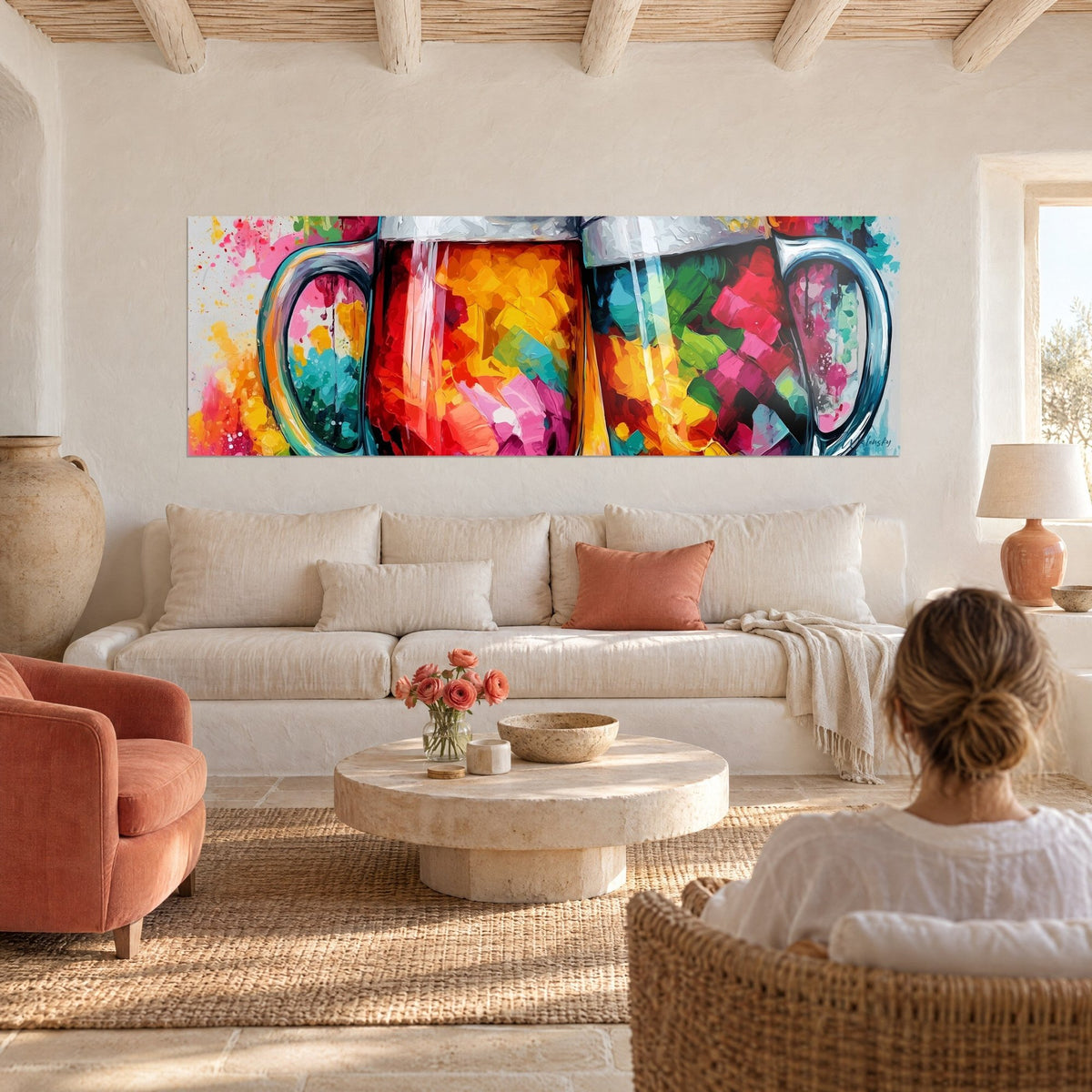 Tableau chopes de bière en éclats orange et turquoise, anses grises, femme de dos, au-dessus d'un canapé dans un salon lumineux
