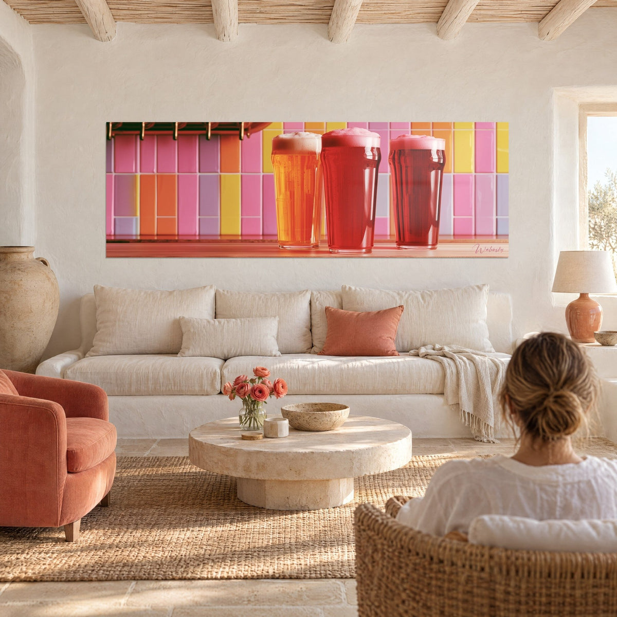 Quadro trio di boccali di birra ambrata e rossa, schiuma cremosa su piastrelle rosa e gialle, donna di spalle, sopra un divano in un soggiorno luminoso