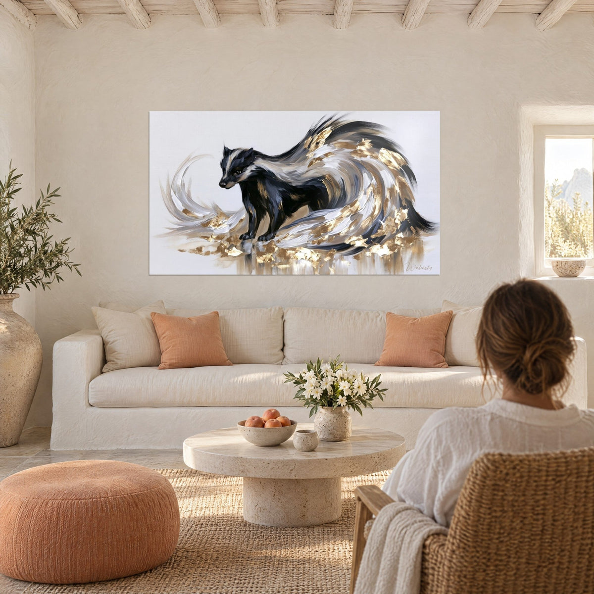 Tableau blaireau noir à bandes blanches, queue en volutes grises et feuilles d'or, au-dessus d'un canapé dans un salon lumineux