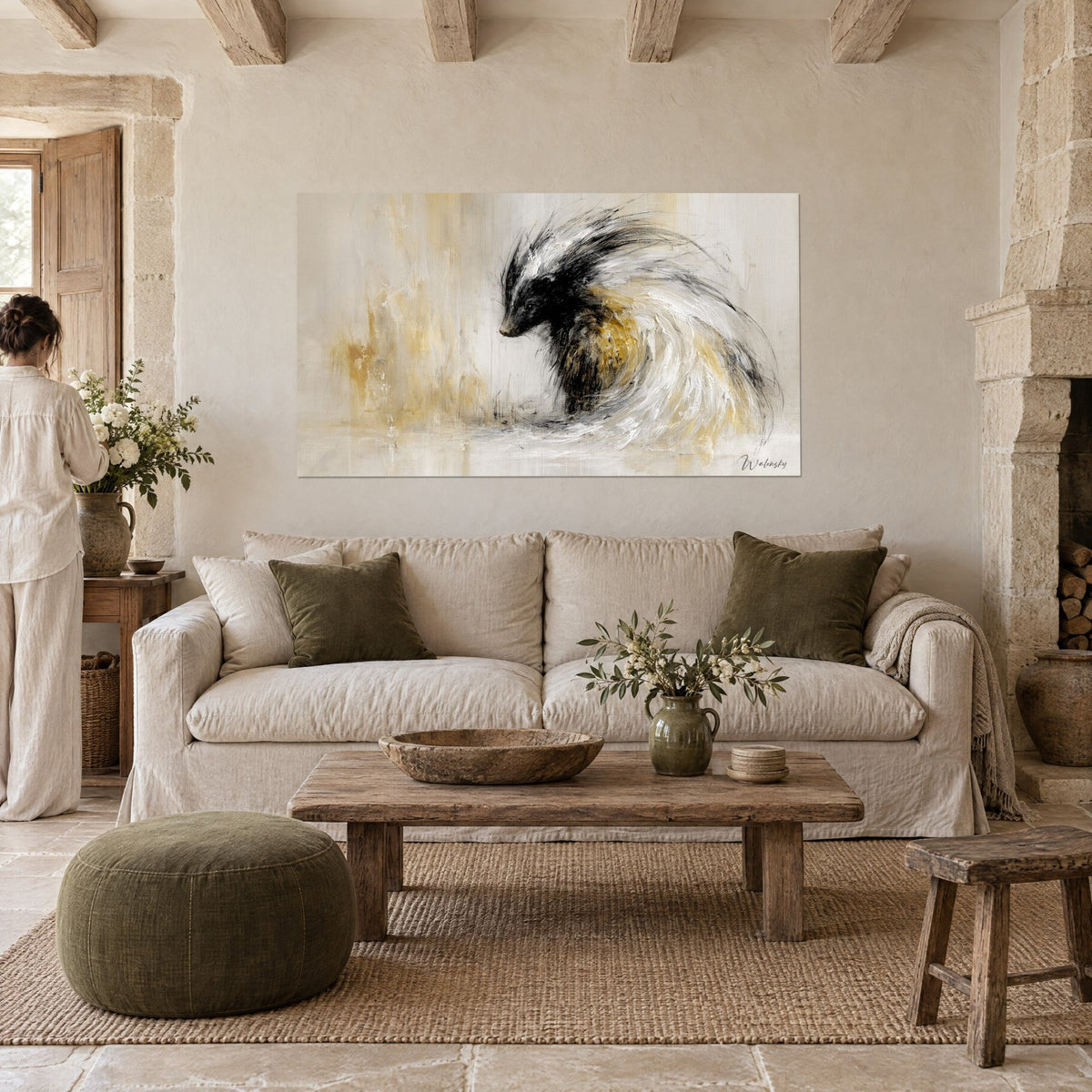 Wall art black and white badger in a swirl, ochre streaks, a woman seen from behind, above a sofa in a bright living room