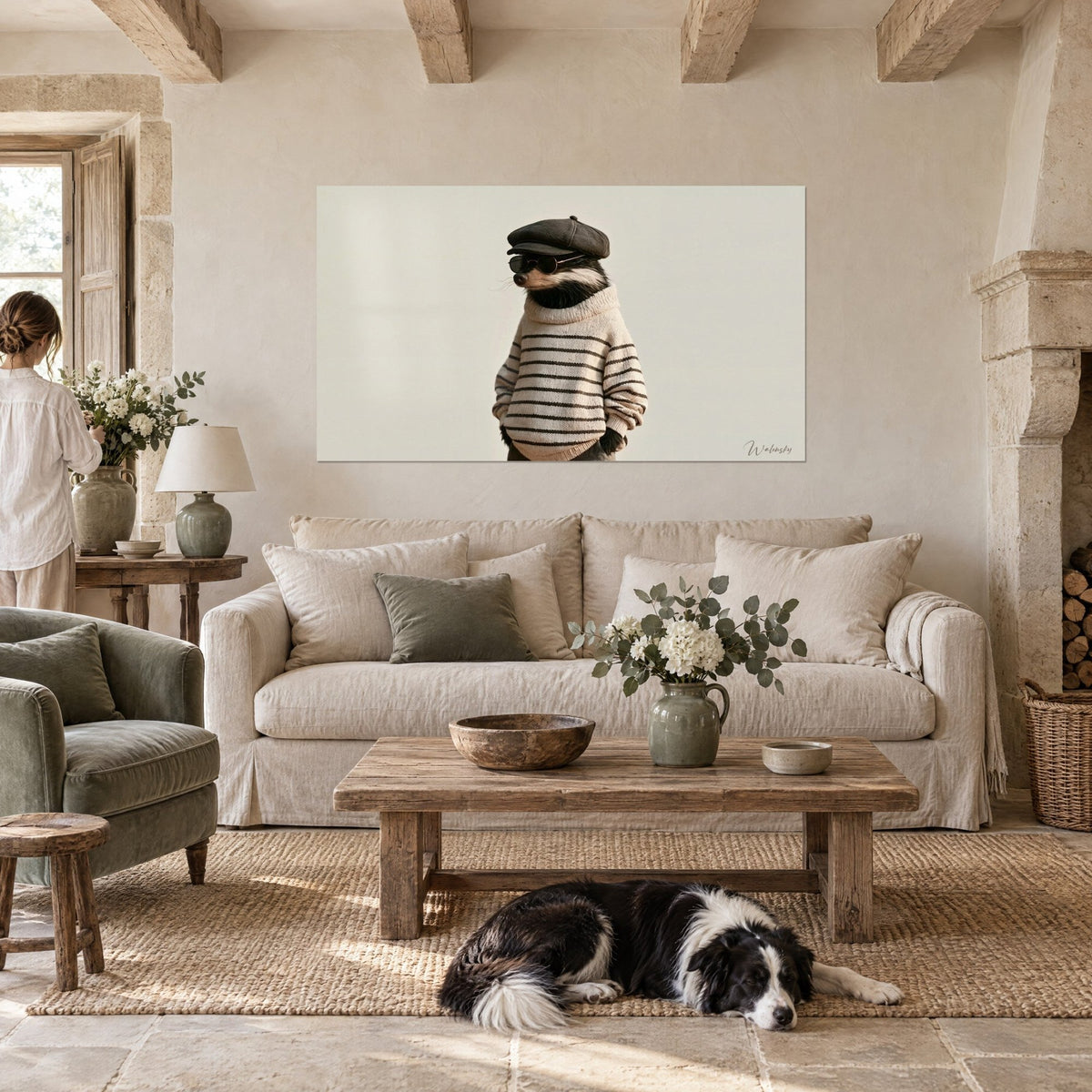 Wall art badger in a beige striped brown nautical sweater, grey flat cap and round glasses, above a sofa in a bright living room
