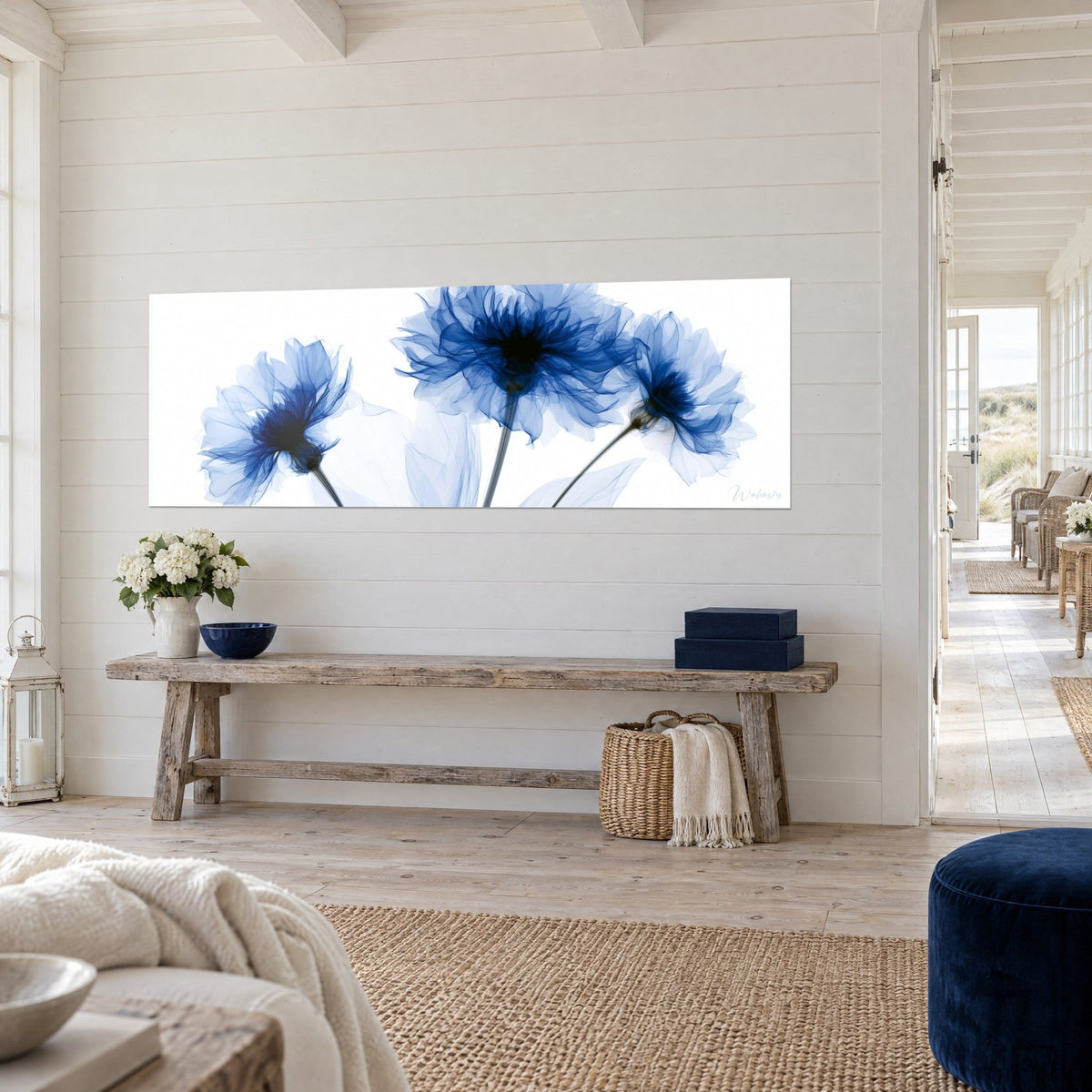 Tableau trois fleurs bleu cobalt aux pétales vaporeux sur fond blanc pur, tiges grises, mur de lattes blanches et banc en bois brut