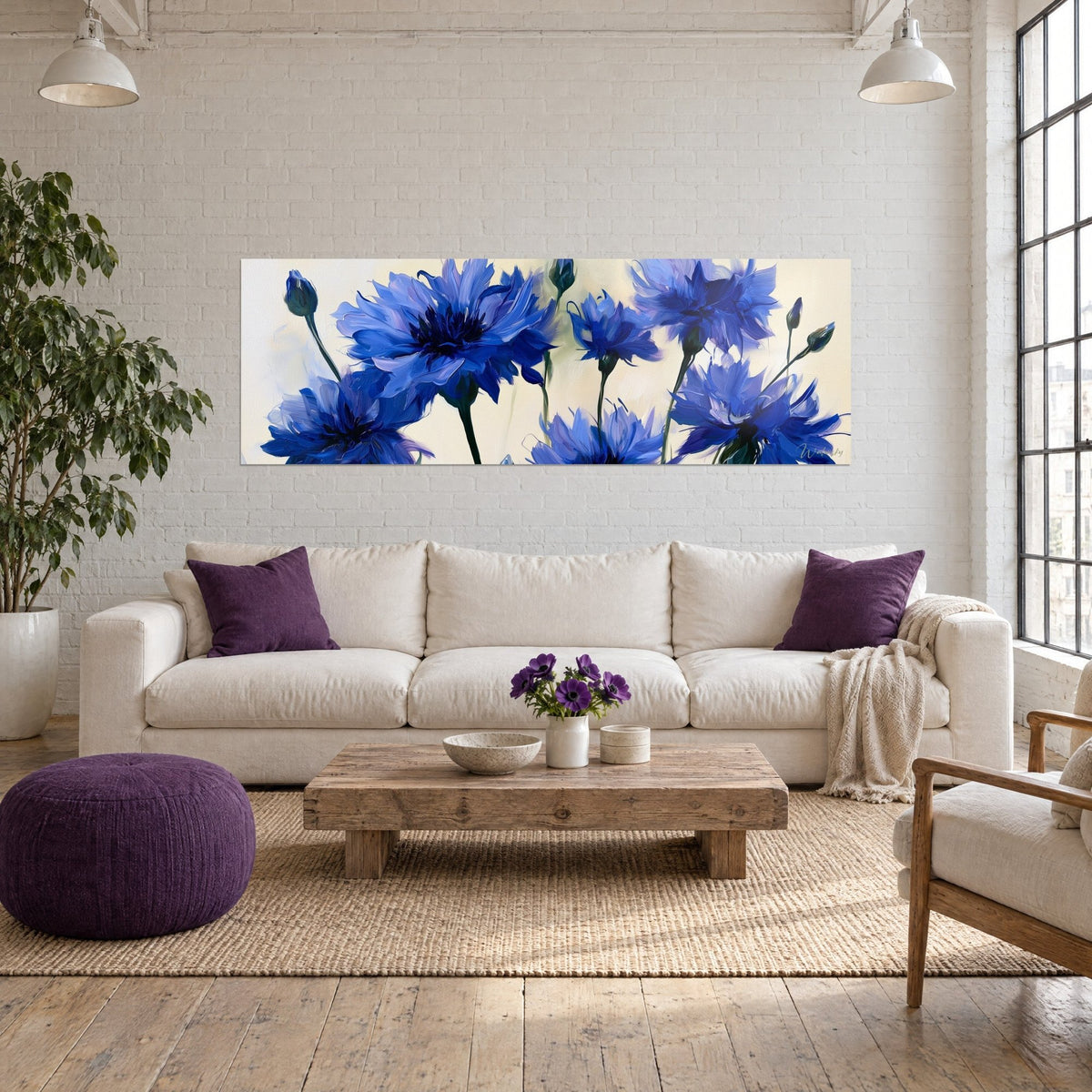 Tableau bleuets peints en bleu cobalt et ivoire, pétales frangés et boutons clos, au-dessus d'un canapé dans un salon lumineux