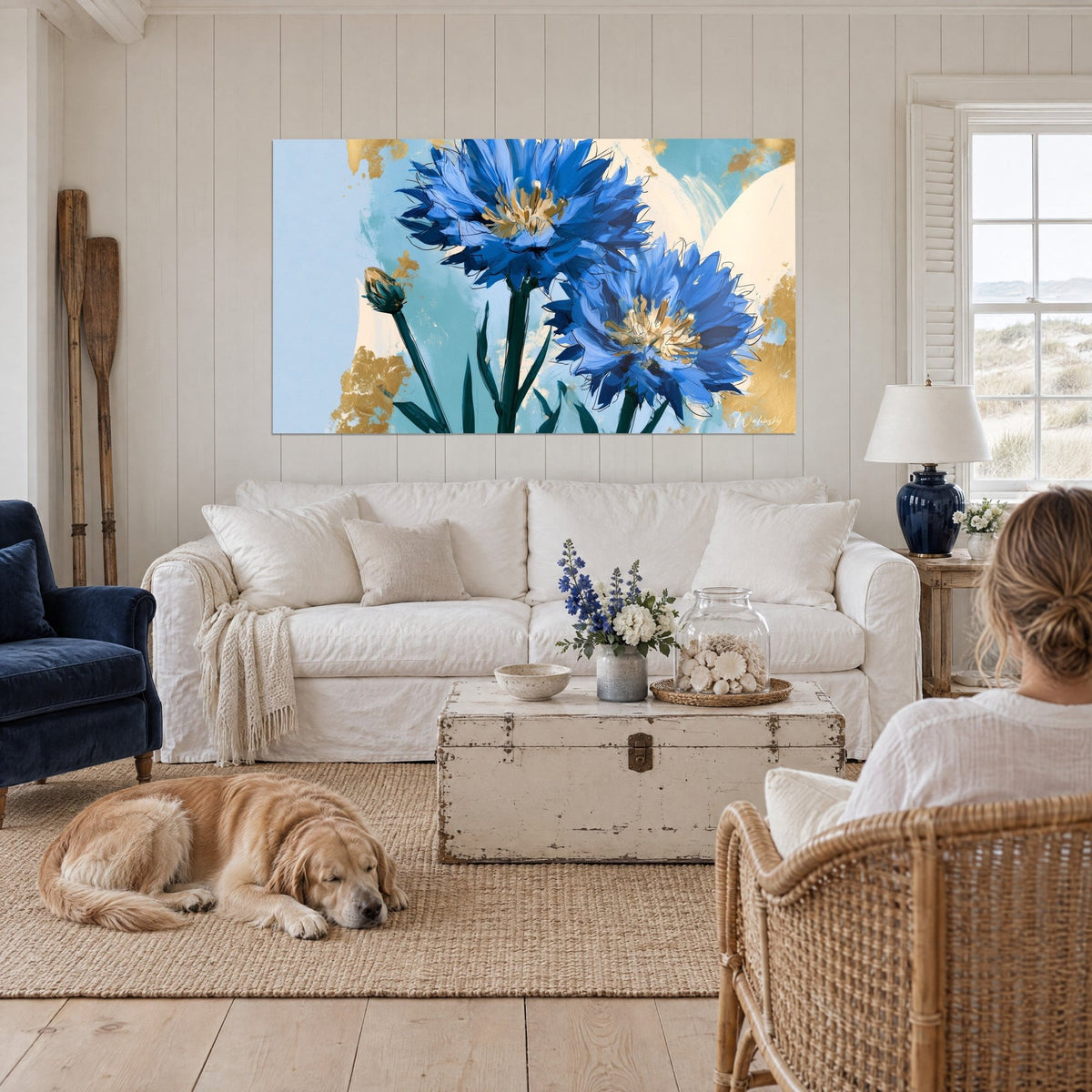 Tableau bleuets cobalt aux cœurs ocre, éclaboussures dorées sur fond turquoise, au-dessus d'un canapé dans un salon lumineux