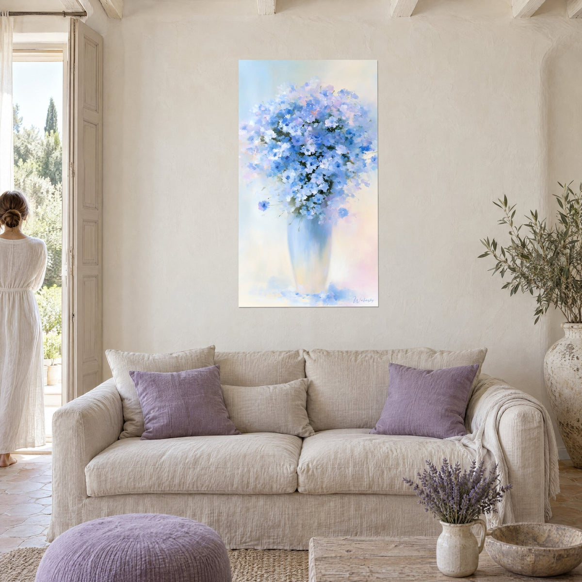 Cuadro frondoso ramo de aciano en un jarrón esbelto azul y blanco, fondo rosa pastel, encima de un sofá en un salón luminoso