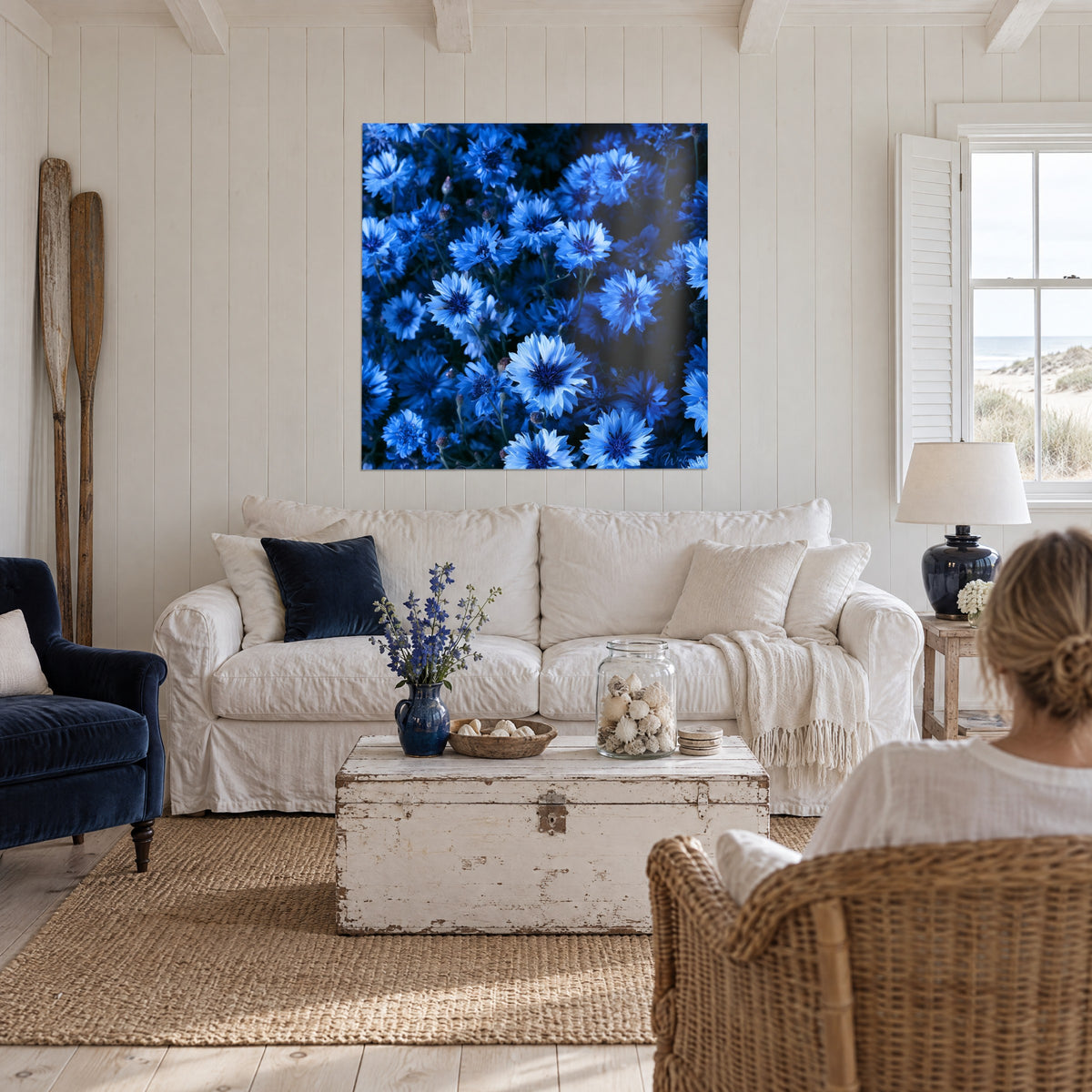 Schilderij korenbloemenveld in marineblauw en azuurblauw, gefranjelde bloembladen, boven een bank in een lichte woonkamer