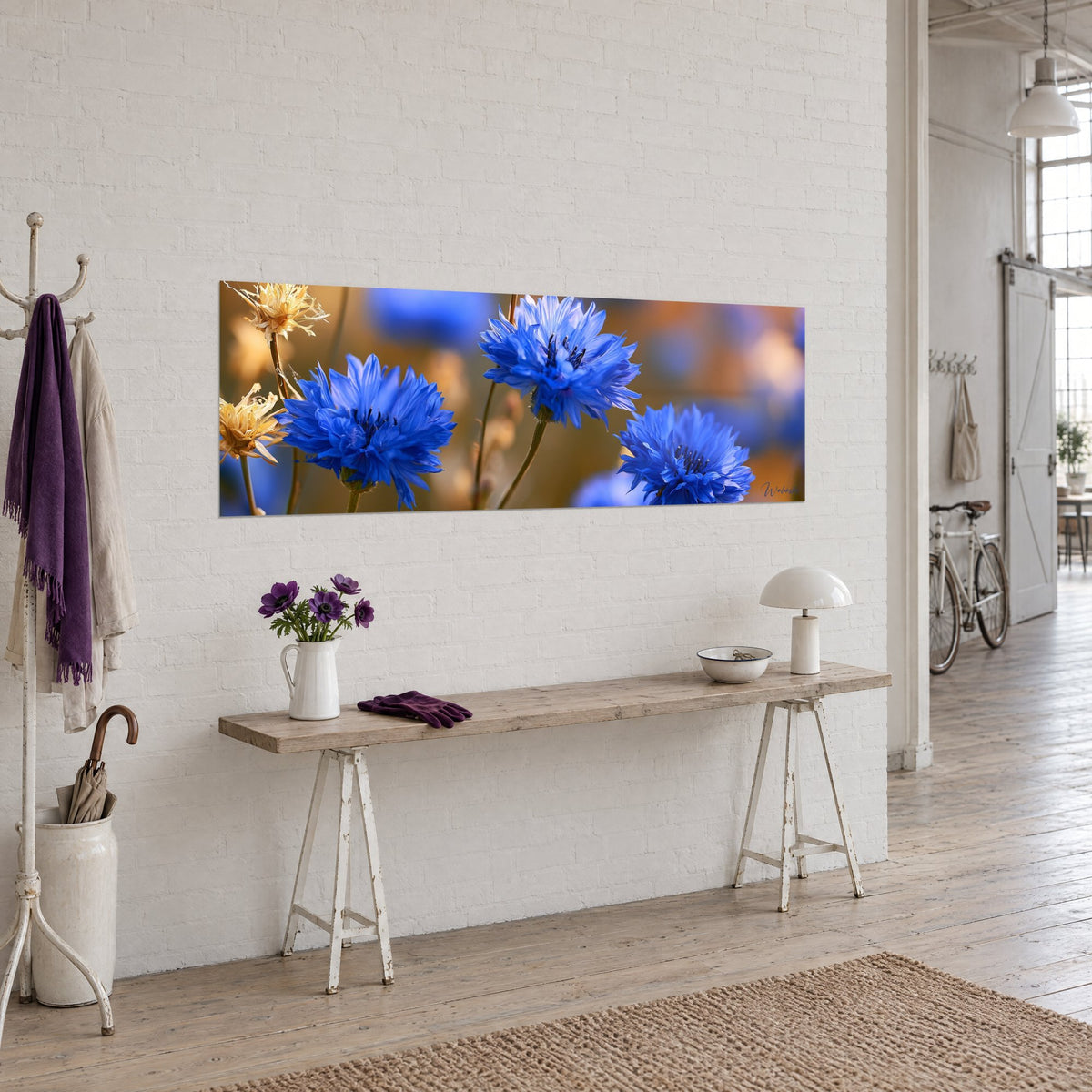 Gemälde Kornblumen in Kobaltblau und vergoldete verblühte Ähren, über einer Holzkonsole in einem hellen Loft