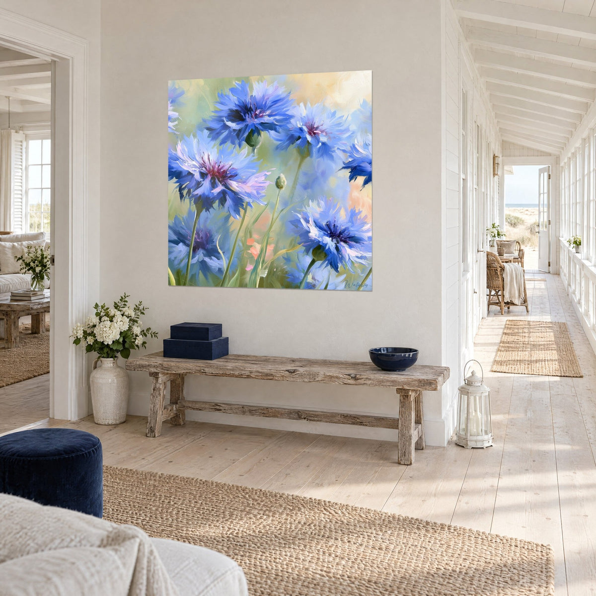 Tableau fleurs de bleuet aux pétales frangés bleu outremer et rose, mur blanc d'un couloir bord de mer