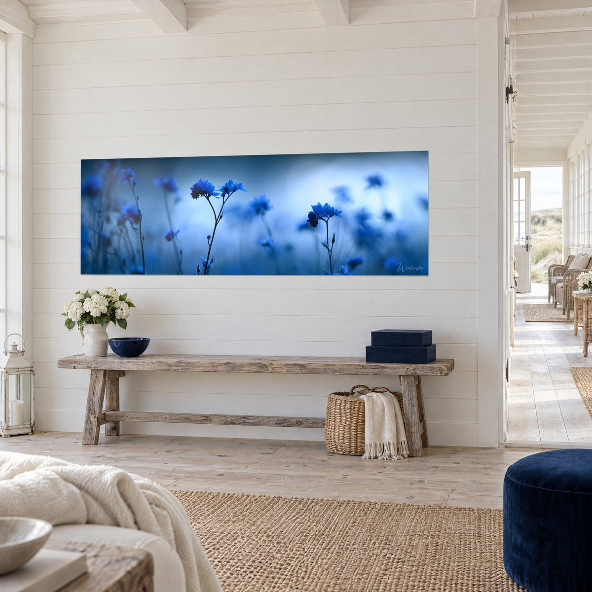 Quadro con fiori di campo blu reale su sfondo di nebbia antracite, vista a tre quarti su una consolle in legno, casa sul mare