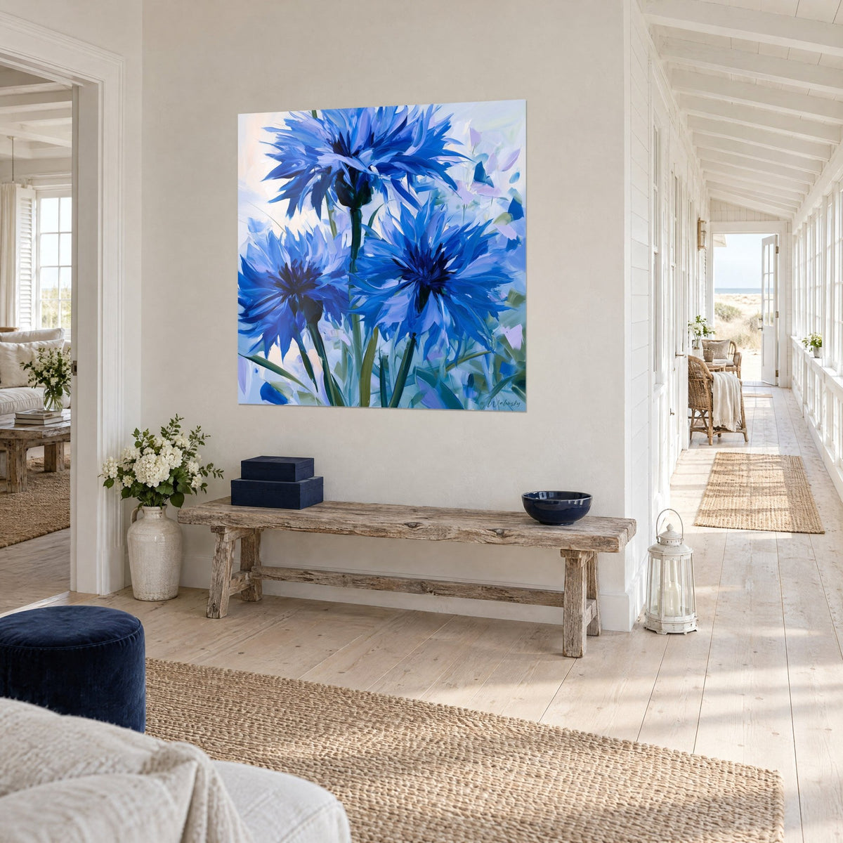 Tableau trois fleurs de bleuet aux pétales effilés bleu outremer et lilas, accroché dans une maison de bord de mer