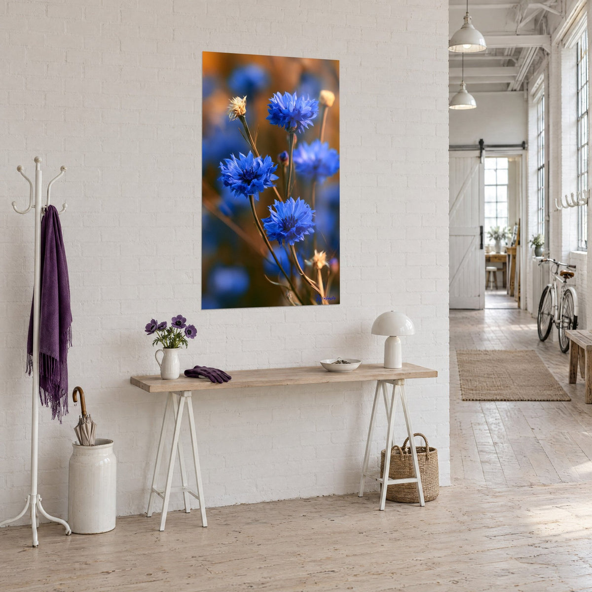 Quadro fiori di campo blu cobalto dai cuori scuri, boccioli secchi dorati, sul muro di mattoni bianchi del loft