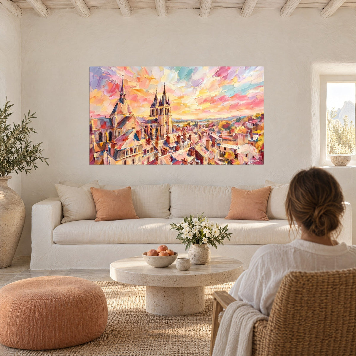 Tableau cathédrale gothique aux flèches ardoise sur ciel rose et doré, au-dessus d'un canapé dans un salon lumineux