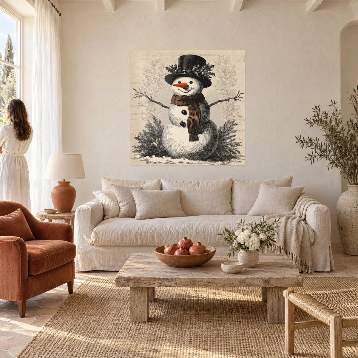 Wall art snowman with black top hat and brown scarf, orange nose, a woman seen from behind, above a sofa in a bright living room