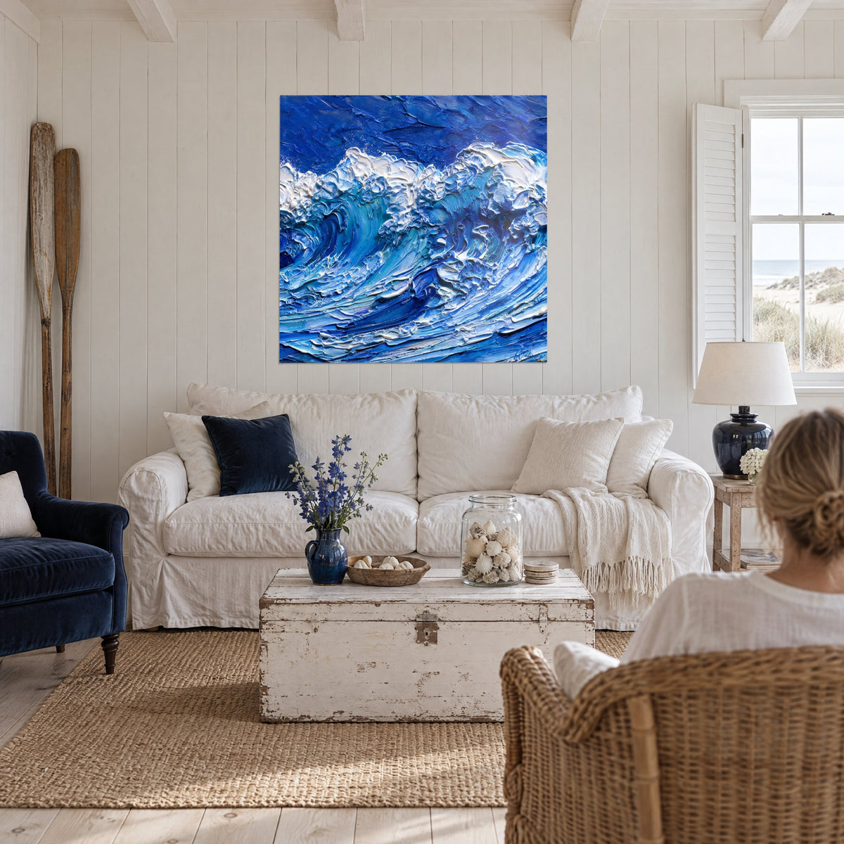 Tableau vague déferlante en bleu cobalt et blanc crémeux, empâtements épais, au-dessus d'un canapé dans un salon lumineux