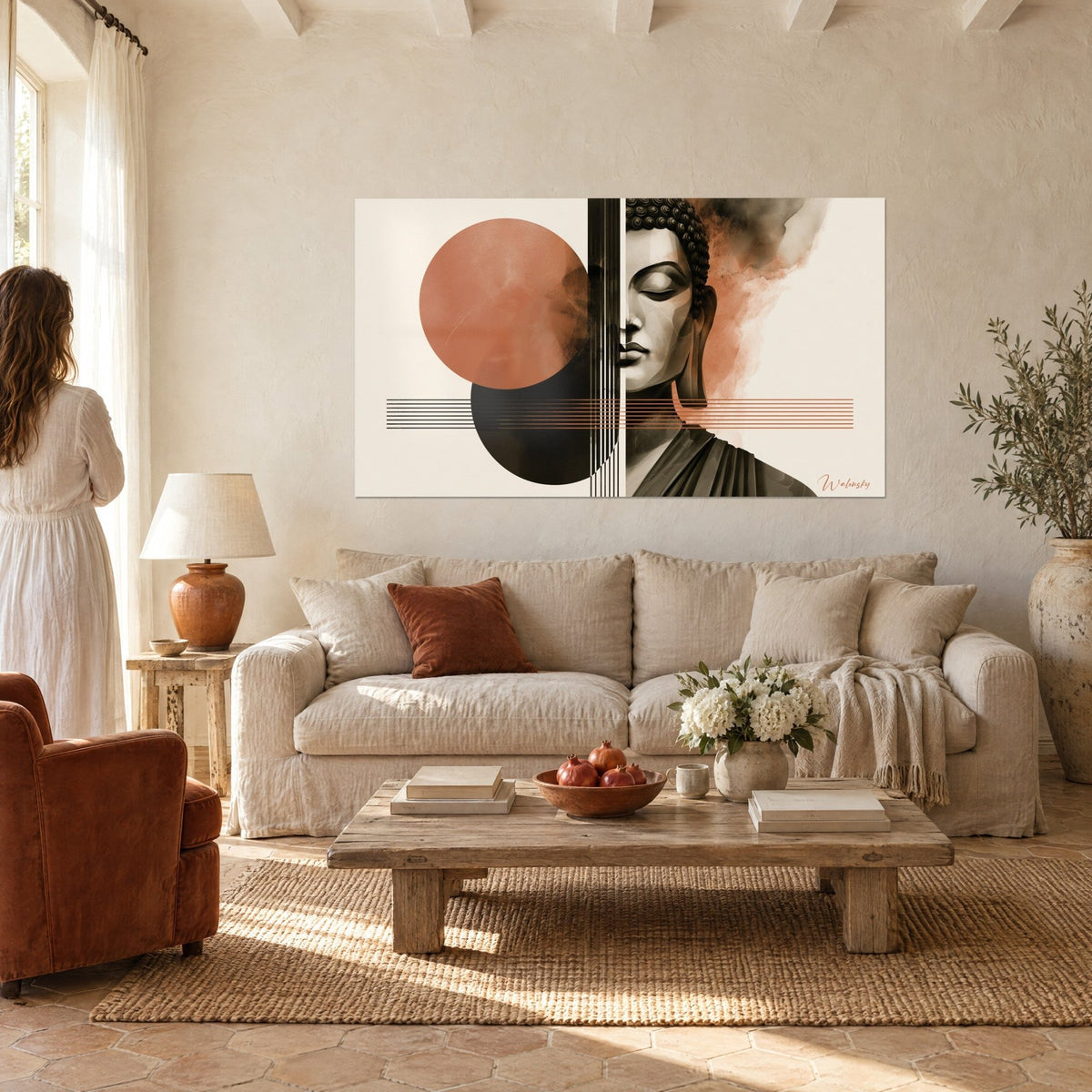 Tableau visage de Bouddha serein, moitié grise, cercle terracotta et lignes noires, au-dessus d'un canapé dans un salon lumineux
