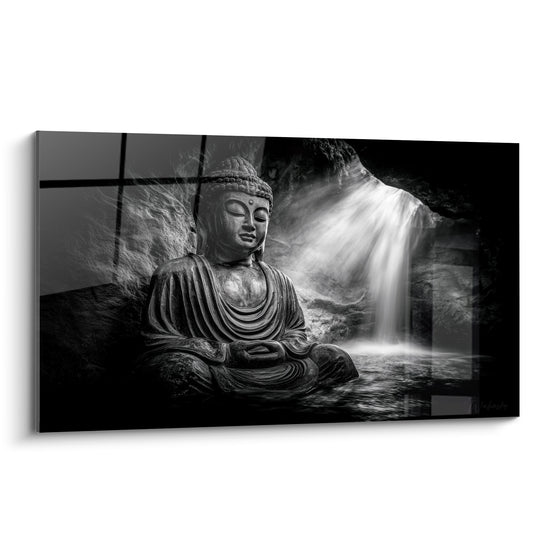 Bouddha en pierre grise assis en méditation devant une cascade blanche jaillissante