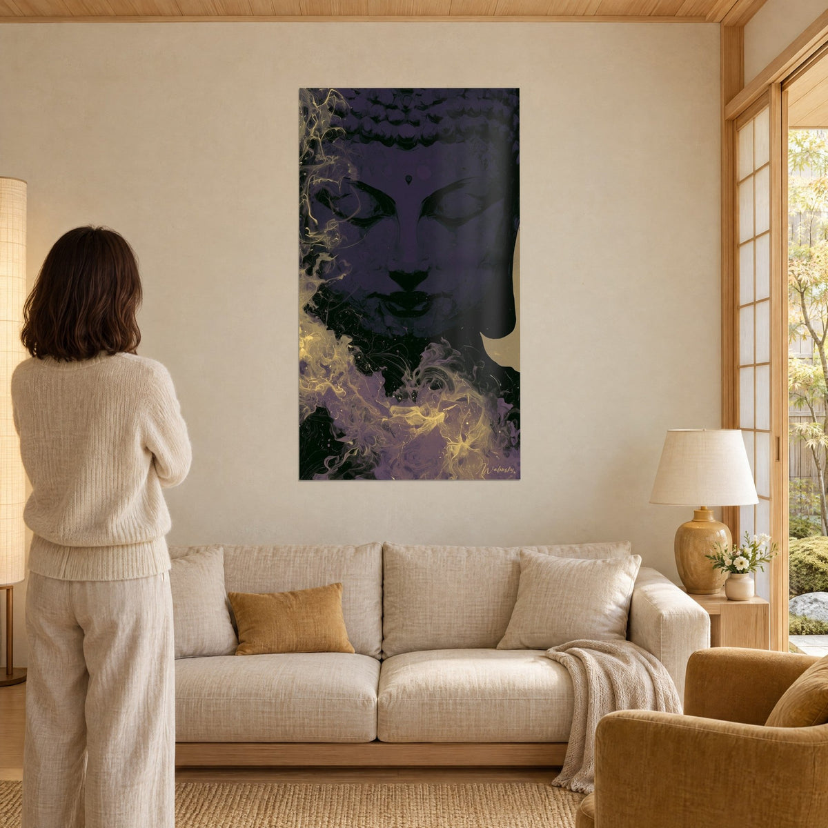 Tableau visage de Bouddha sculptural violet nuit, volutes dorées en bas à gauche, femme de dos, au-dessus d'un canapé dans un salon lumineux