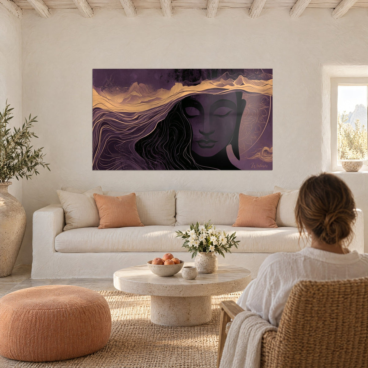 Cuadro rostro de Buda con los párpados cerrados, olas doradas sobre fondo ciruela, encima de un sofá en un salón luminoso