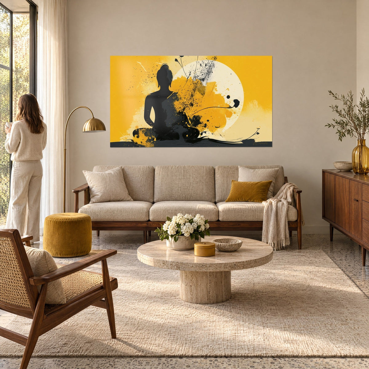 Tableau Bouddha en silhouette noire assis devant un disque crème, éclaboussures jaune moutarde, au-dessus d'un canapé dans un salon lumineux