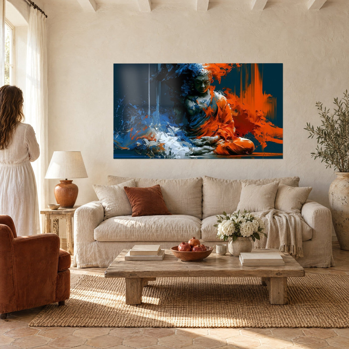 Cuadro Buda en meditación, túnica naranja flamígera y salpicaduras azules, colgado encima de un sofá en un salón luminoso