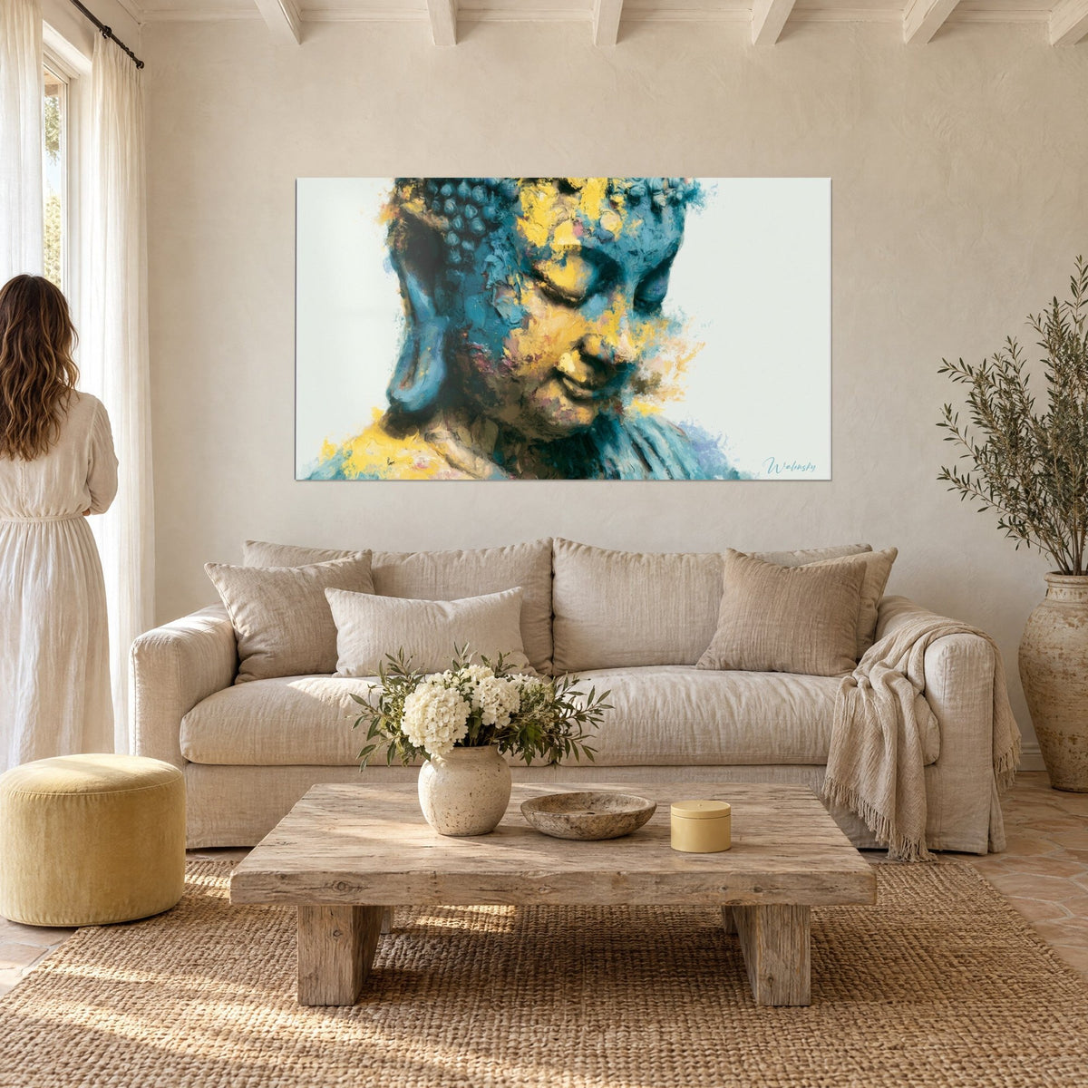 Quadro Buddha con palpebre chiuse, schegge di blu turchese e giallo zafferano, donna di spalle sopra un divano in un soggiorno luminoso