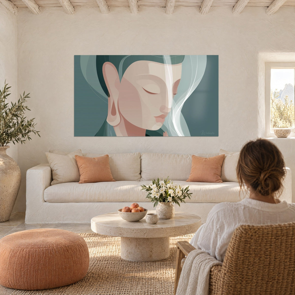 Tableau visage de Bouddha aux paupières closes, beige rosé et vert d'eau, mèches blanches, au-dessus d'un canapé dans un salon lumineux