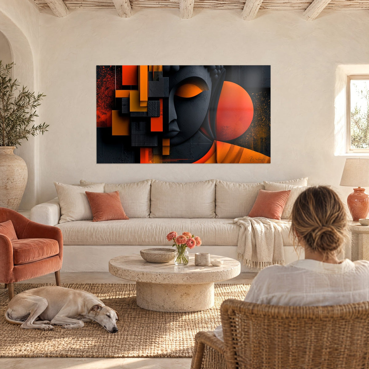 Tableau visage de Bouddha anthracite aux paupières orange, au-dessus d'un canapé dans un salon lumineux