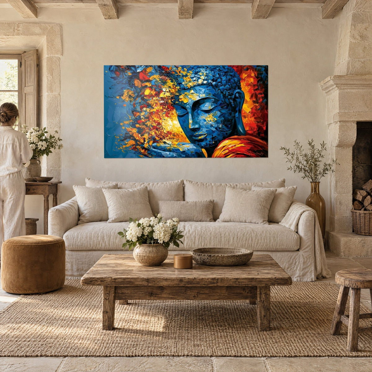 Tableau visage de Bouddha bleu cobalt aux éclats orange et or, épaule rouge, au-dessus d'un canapé dans un salon lumineux