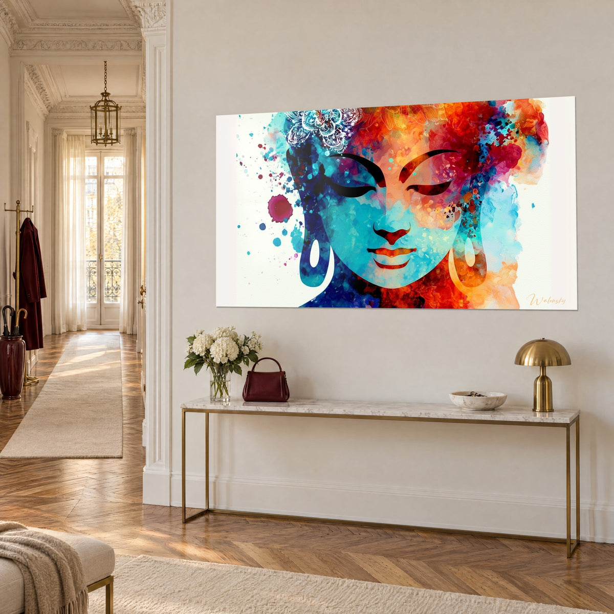 Tableau portrait aquarelle d'un Bouddha serein, joue bleu azur et chevelure orange, éclaboussures magenta, sur mur beige au-dessus d'une console