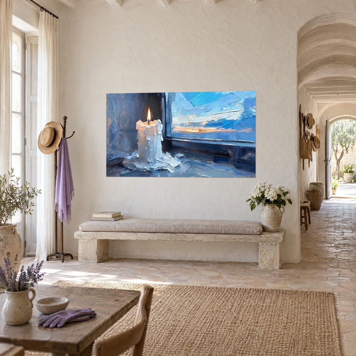 Cuadro de una vela crema con llama dorada, ventana con parteluces y nubes azules, colgado en un pasillo del mas provenzal
