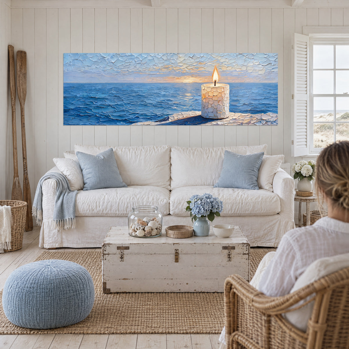 Gemälde weiße Kerze aus Mosaik mit goldener Flamme, kobaltblaues Meer, über einem Sofa in einem hellen Wohnzimmer