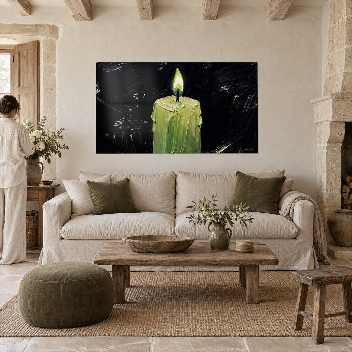 Cuadro de una vela verde con llama blanca sobre fondo negro, en empaste grueso, colgado encima de un sofá en un salón luminoso