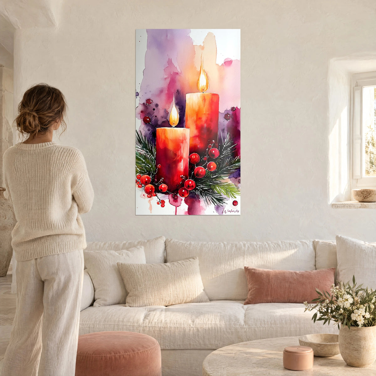 Wall art two coral red candles with golden flames on holly and scarlet berries, woman seen from behind above a sofa in a bright living room