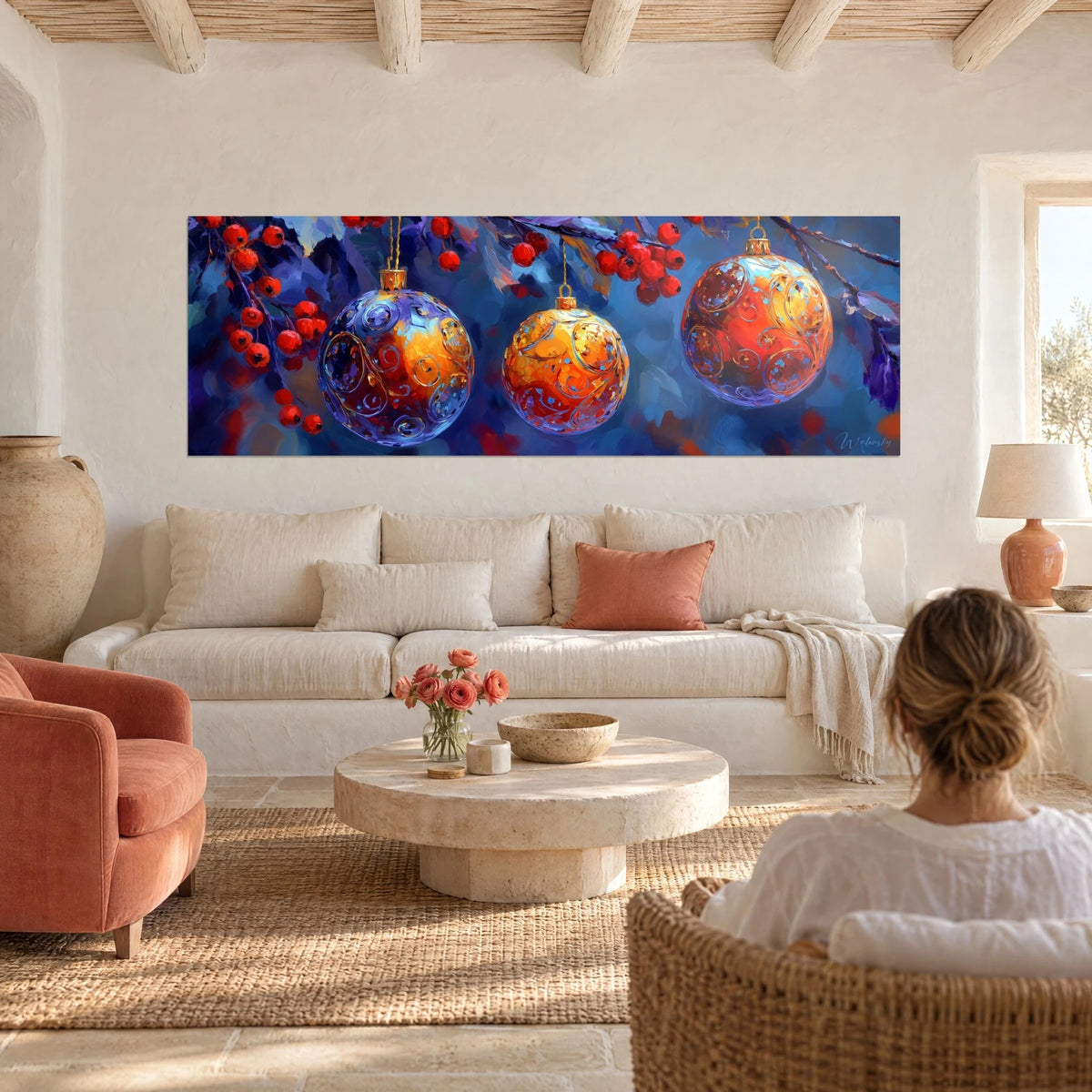 Tableau trois boules de Noël bleu indigo et orange ambré, baies rouges, femme de dos au-dessus d'un canapé dans un salon lumineux