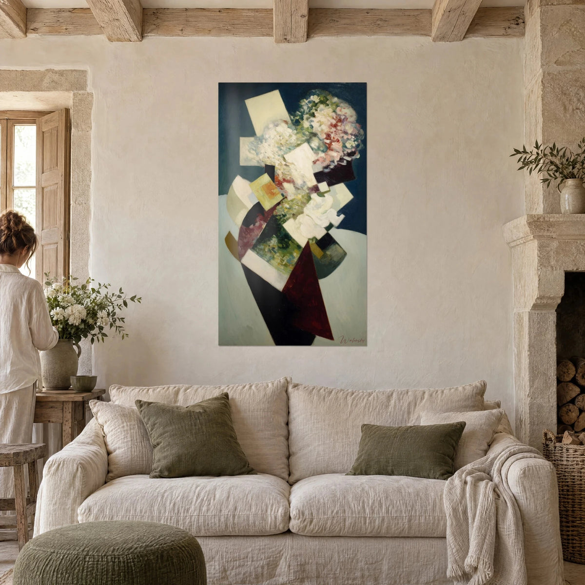 Tableau bouquet éclaté en rectangles ivoire sur fond bleu nuit, pétales roses et verts, une femme de dos, au-dessus d'un canapé dans un salon lumineux