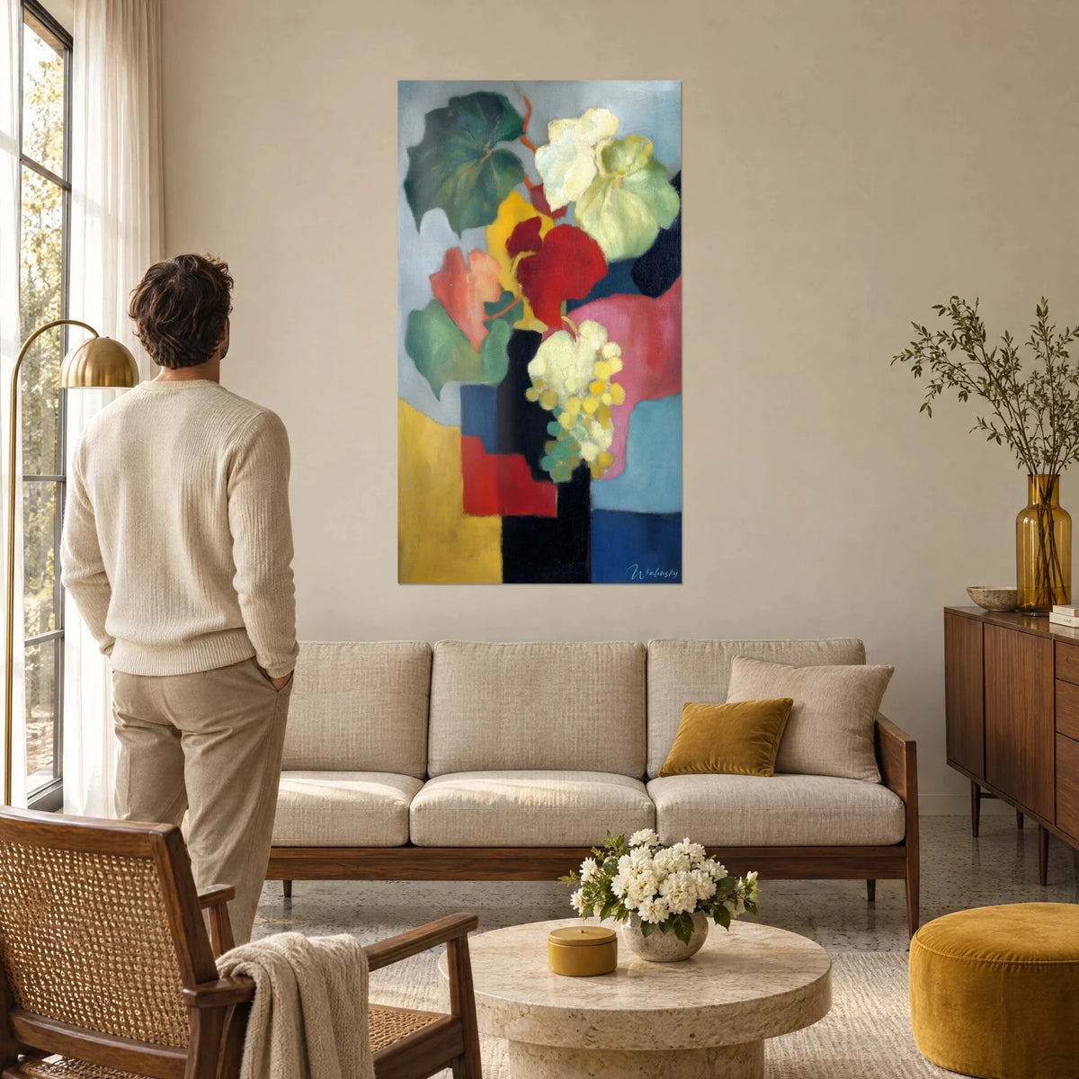 Quadro mazzo di tralci di vite rossi e verdi su sfondo blu, uomo di spalle sopra un divano in un soggiorno luminoso