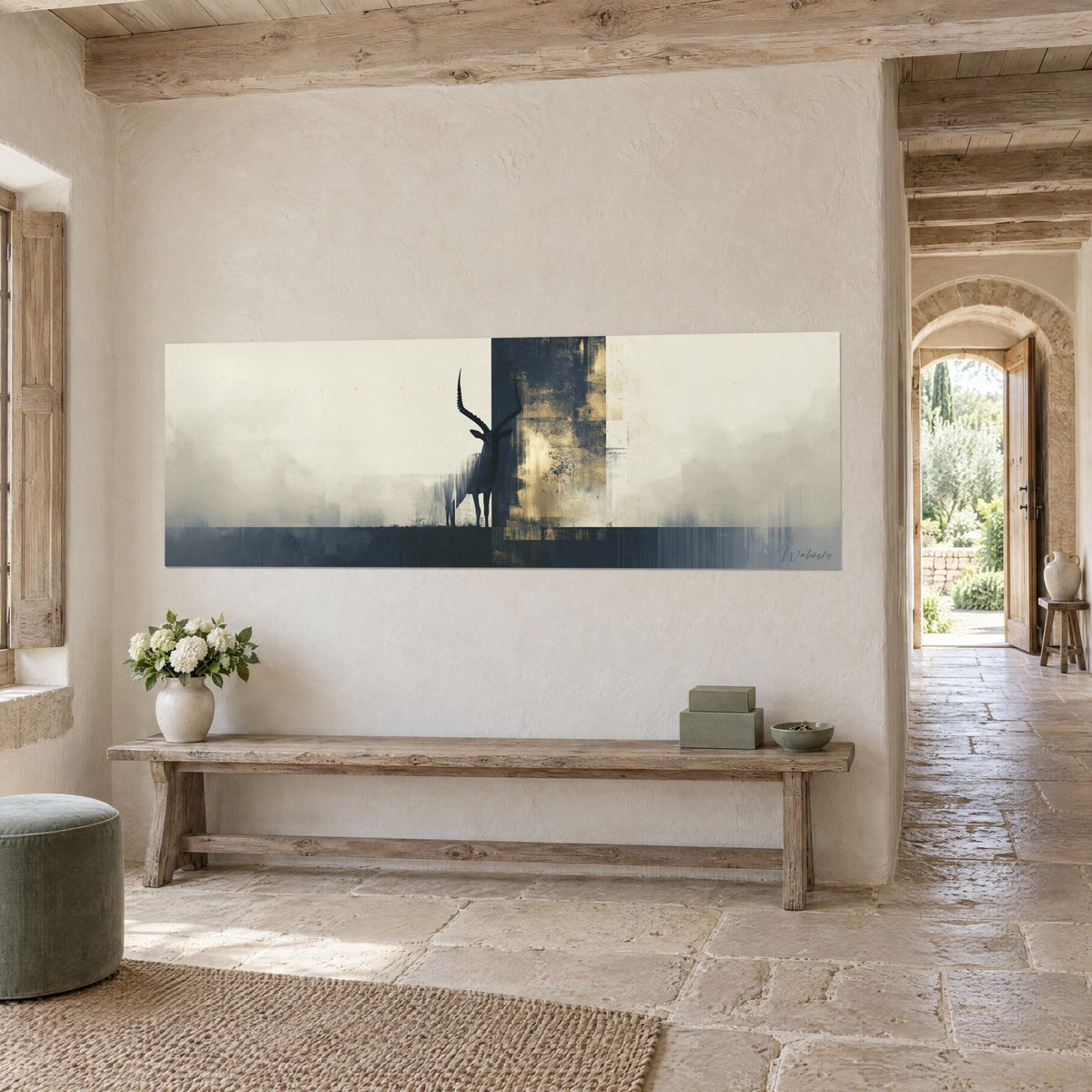 Tableau bouquetin sombre, longues cornes annelées, bandeau bleu nuit et or vieilli, mur de pierre claire et banc en bois