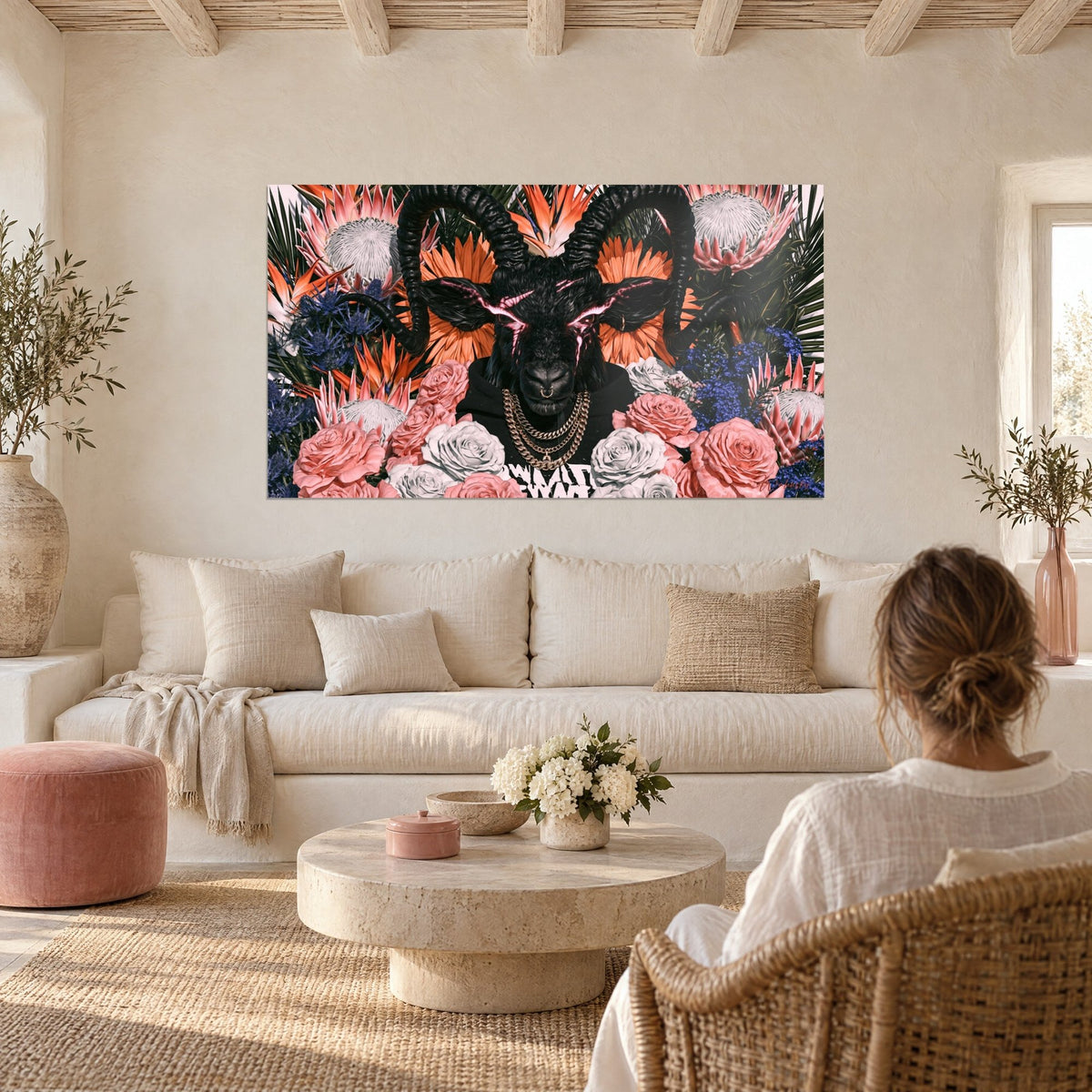 Wall art black ibex with spiralled horns, pink lightning and salmon roses, above a sofa in a bright living room