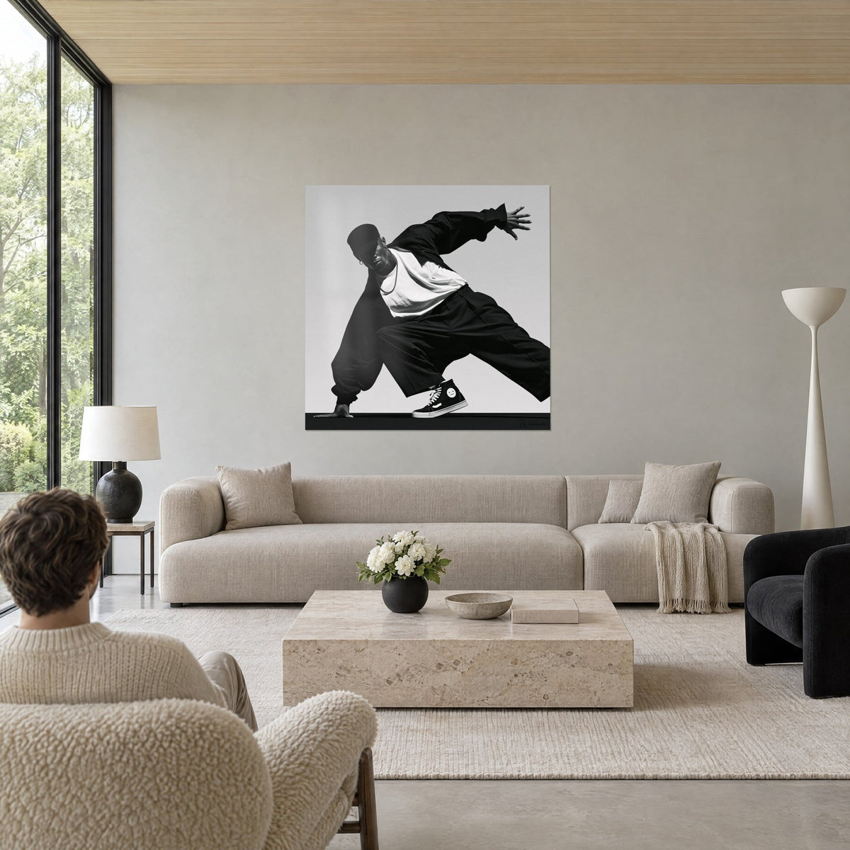 Tableau danseur de breakdance en casquette noire, haut blanc et pantalon ample, fond gris clair, au-dessus d'un canapé dans un salon lumineux